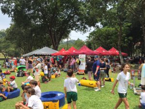 People and kids sitting on the grass in Malaysia